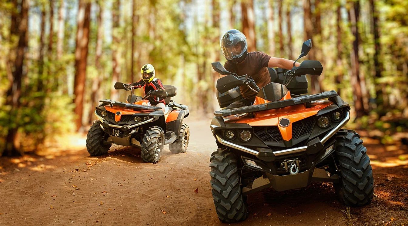 Friends riding an ATV through open terrain